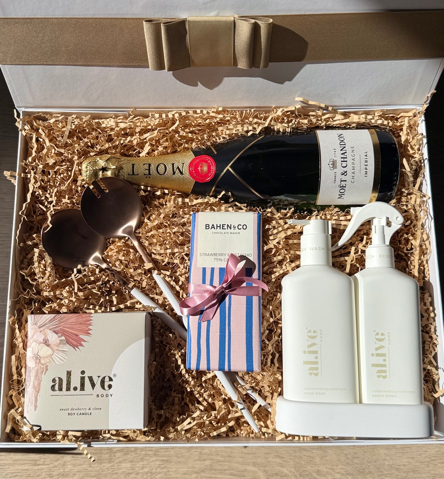Dwell & Delight luxury gift box with Moët & Chandon, al.ive body products, copper salad servers, and Bahen & Co chocolate in premium packaging
