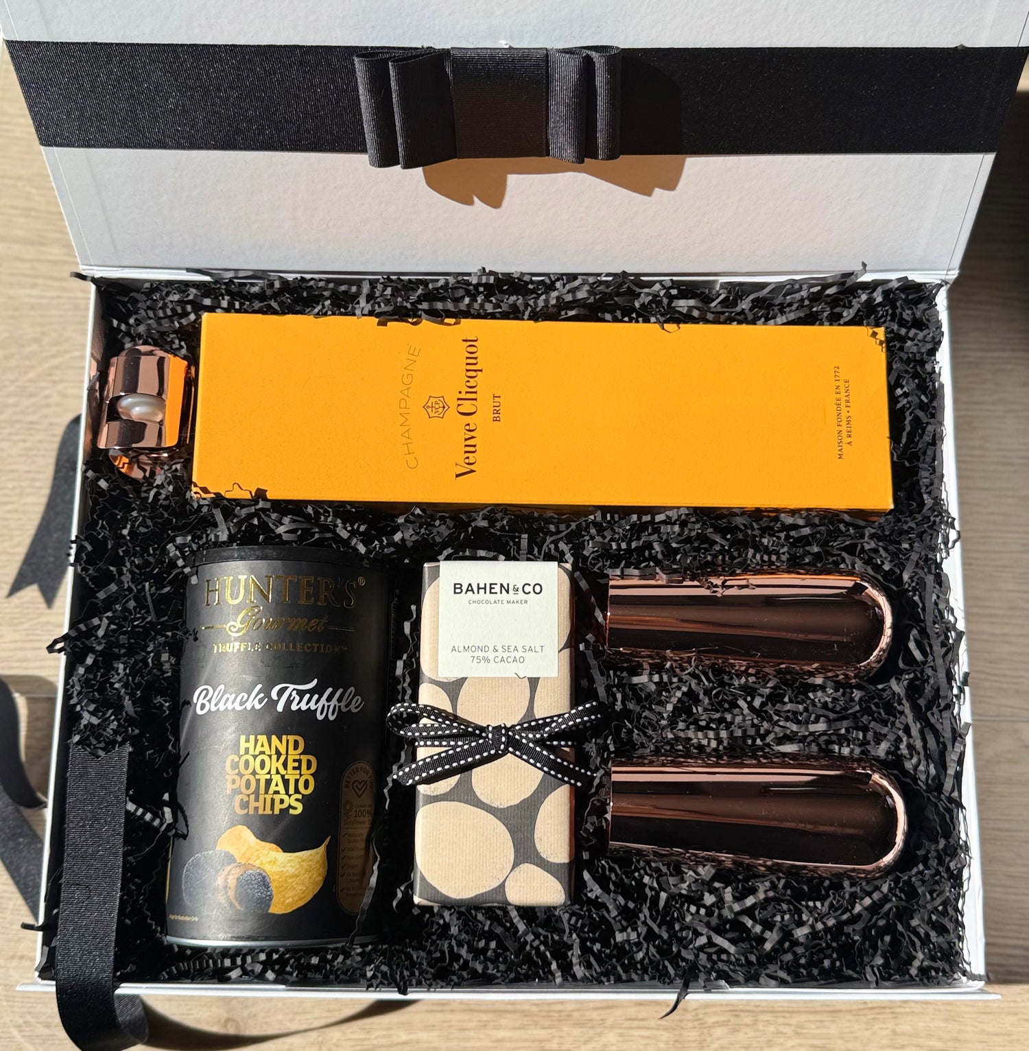 Celebrate in style with the Golden Hour gift box – featuring Veuve Clicquot, artisan chocolate, luxe copper glassware, and gourmet snacks.
