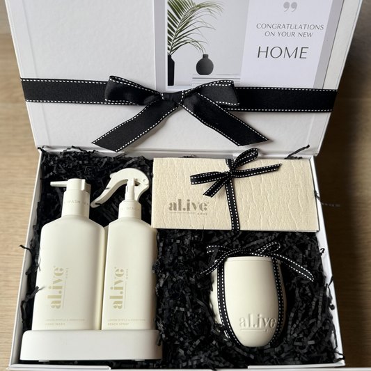 The al.ive Edit gift box with lemon & pomegranate kitchen duo, sweet dewberry & clove candle, and biodegradable dish cloths in elegant packaging with black ribbon