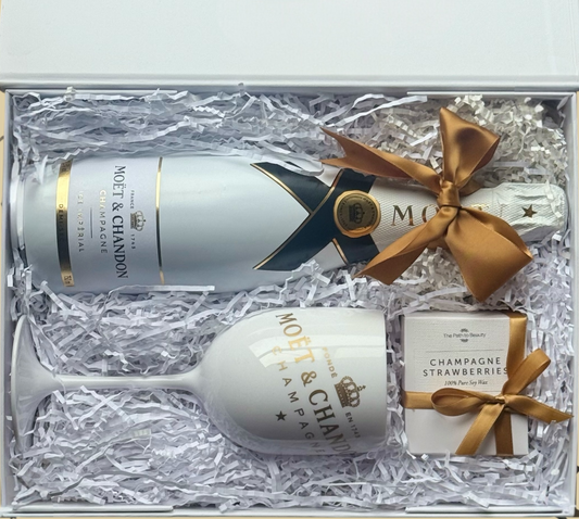Limited edition Blanc & Gold Celebration gift box with Moët & Chandon Ice Imperial champagne, branded champagne glass, and champagne-scented soy candle, elegantly wrapped with gold ribbon.